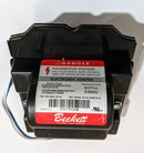 A Beckett electronic igniter for oil furnaces, with a black plastic housing and a red label warning about hazardous voltage.
